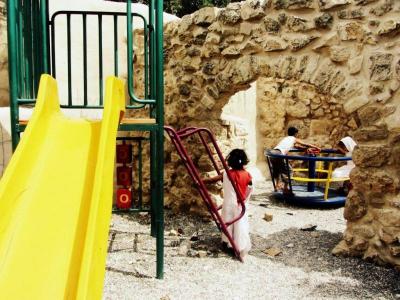 Children play on structures in Abwein playground