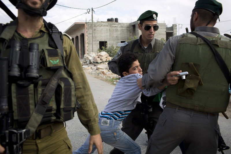 Israeli occupation forces try to arrest a Palestinian boy during a demonstration against Israel’s wall in the West Bank village of al-Maasara, 9 November 2012. Oren Ziv ActiveStills