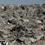 Palestinians make their way past the rubble of destroyed houses and buildings in Jabalia